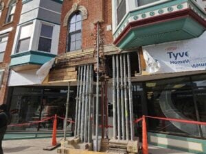 Steel shoring jacks supporting a brick building during structural repair.